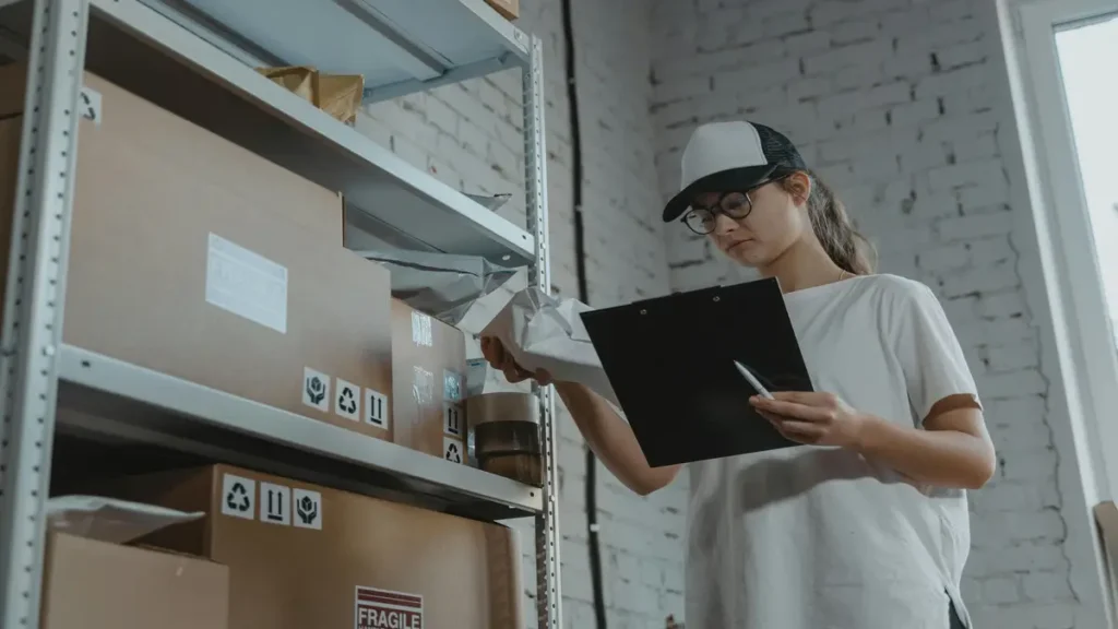 Warehouse employee checking inventory and managing packages on shelves