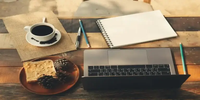 Top 10 side hustles setup: laptop, notebook, and coffee on a rustic desk for remote work and creative planning