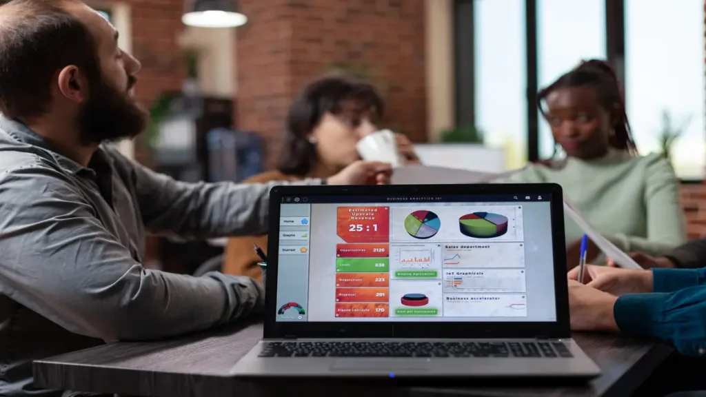 Team meeting with laptop displaying AI financial analytics dashboard for business forecasting and budgeting